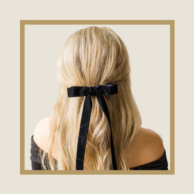 Image of a blonde woman wearing the Foxy Locks black hair bow